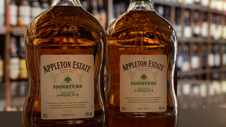 Two bottles of Appleton Estate Signature on a liquor store counter top.