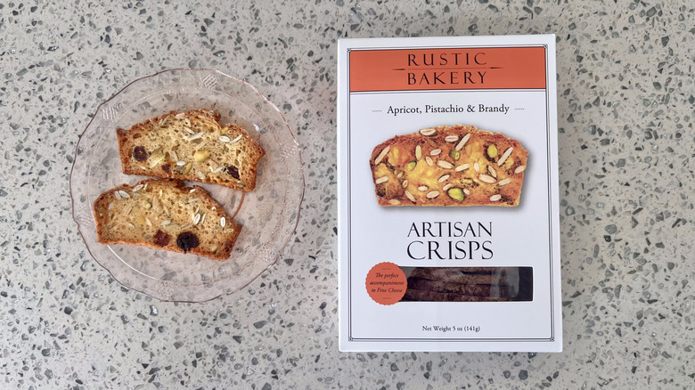 Apricot, Pistachio, & Brandy Crisps on a plate with its packaging