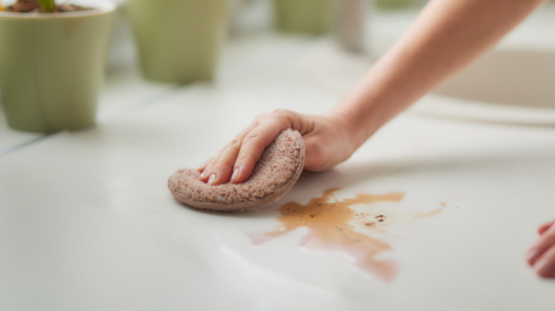 A person wipes up a spill in the kitchen