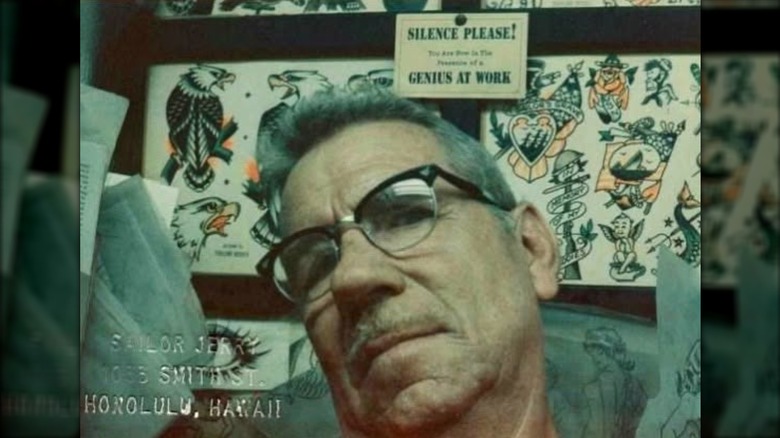 Norman Collins posing in his tattoo shop