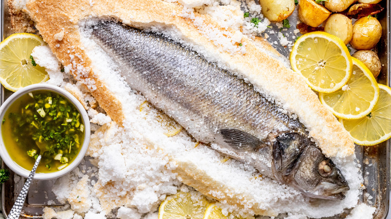 Whole fish covered in salt on tray