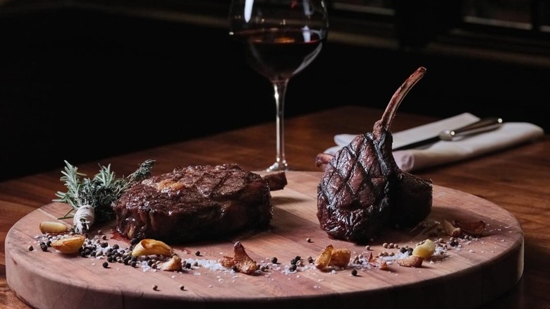Two steaks on a wooden cutting board