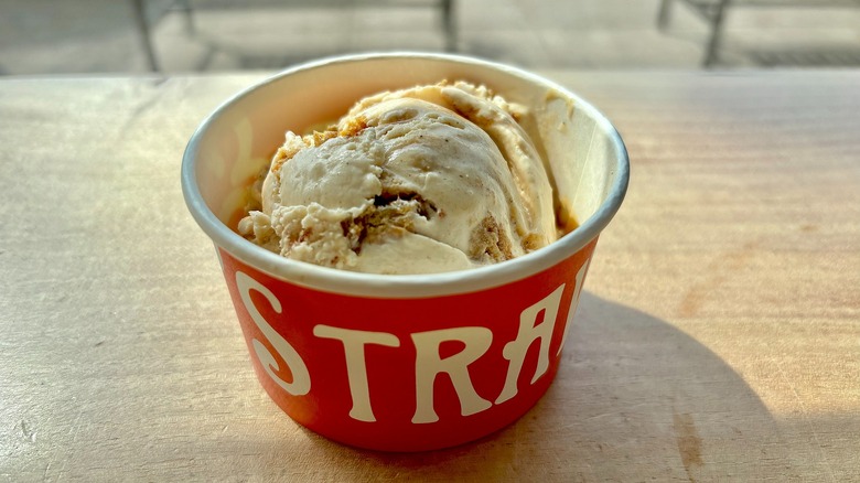 Cup of Salt & Straw Apple Cider Donut ice cream on wooden surface