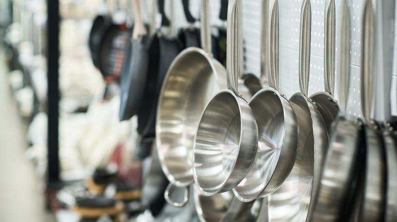A hanging row of stainless steel pans