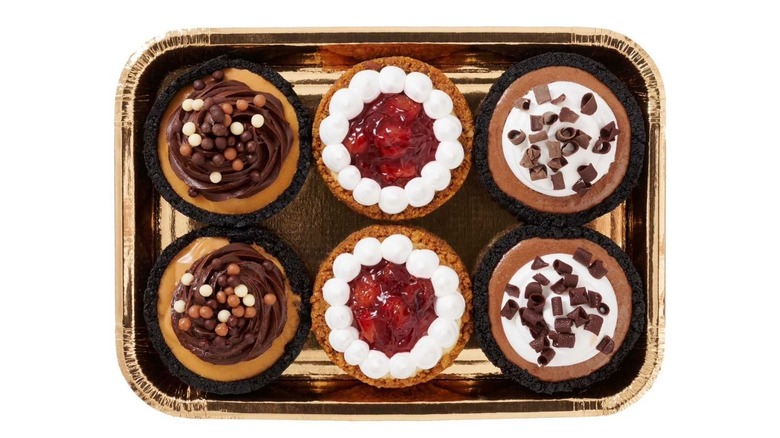 Six mini pies in a container sold at Sam's Club on white background