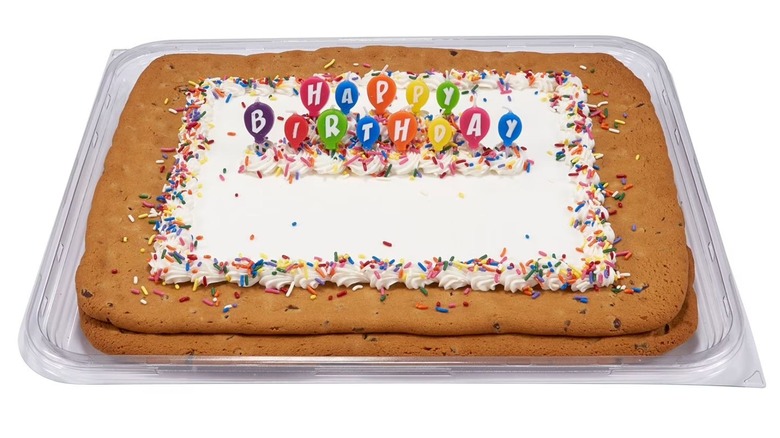 A chocolate chip cookie cake decorated for a birthday party on white background