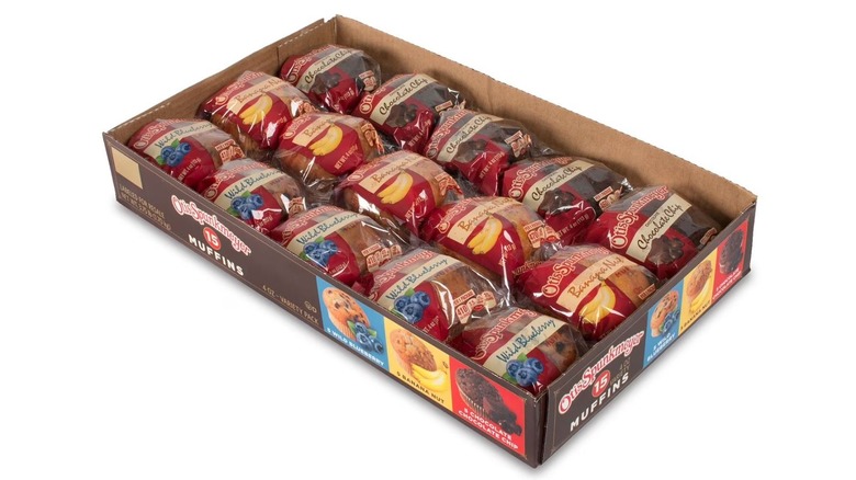 A container of muffins in a variety pack on white background