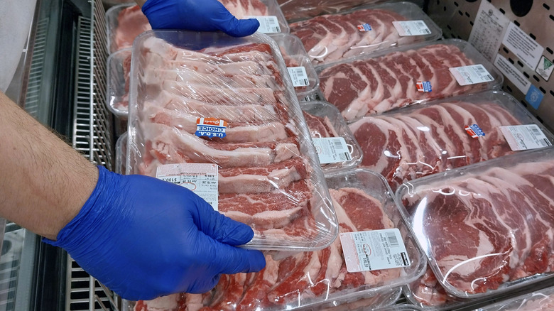 Costco butcher arranges meat display
