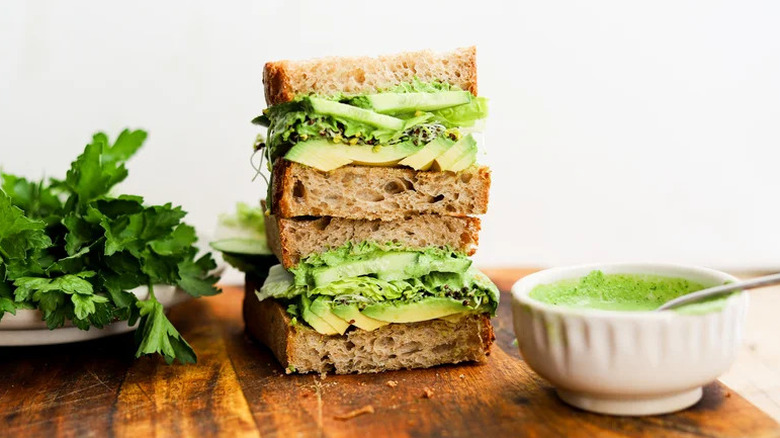 Green Goddess Avocado Sandwich stacked on wooden board
