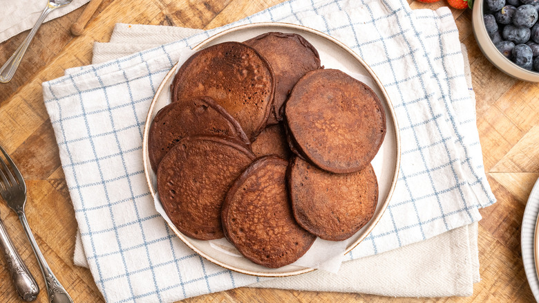 aerial view of high protein chocolate pancakes on a plate over a cloth