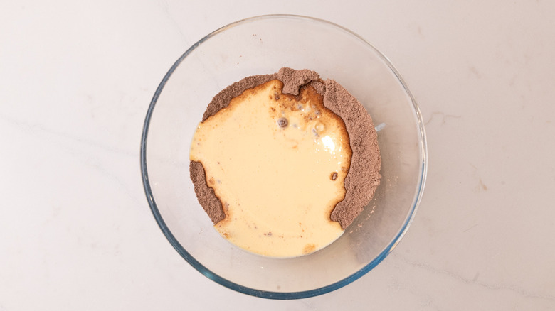 aerial view of wet and dry ingredients combined in a glass bowl
