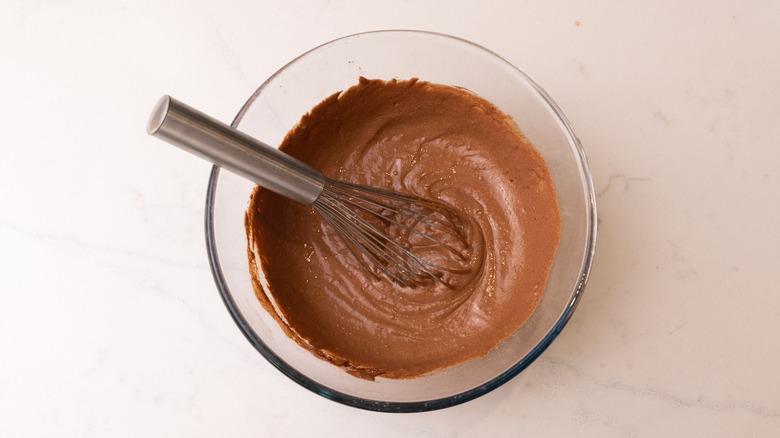 aerial view of chocolate pancake batter in bowl with whisk inside
