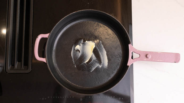 aerial view of pink pan containing melted butter on hob