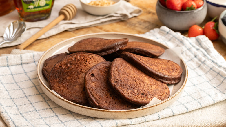 high protein chocolate pancakes on a plate over a cloth