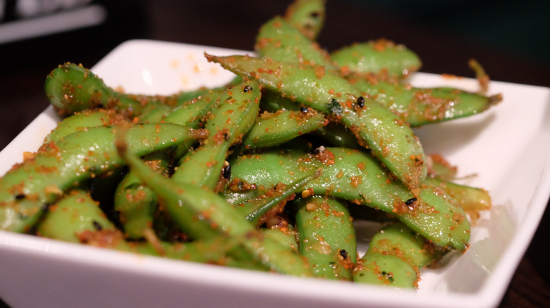 Sauteed edamame beans in a bowl with toppings
