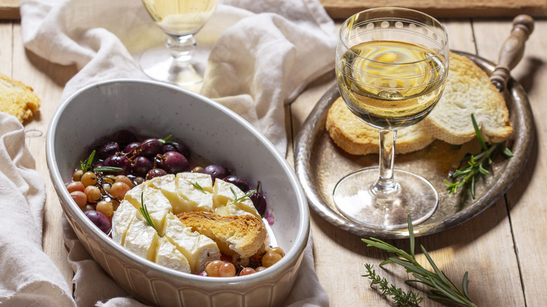 White wine with toast grapes and baked cheese.
