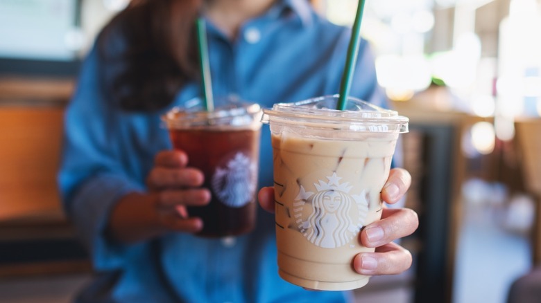 Hands holding a Starbucks Iced Coffee and Latte 