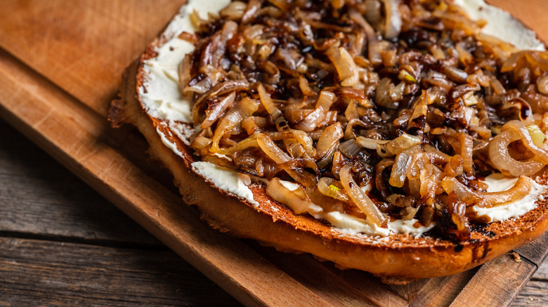 caramelized onions on dough and wood board