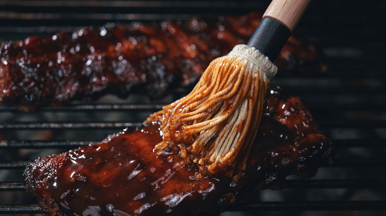 Brushing barbecue sauce onto ribs