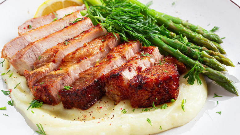 Plate of pork chop with mashed potatoes and asparagus