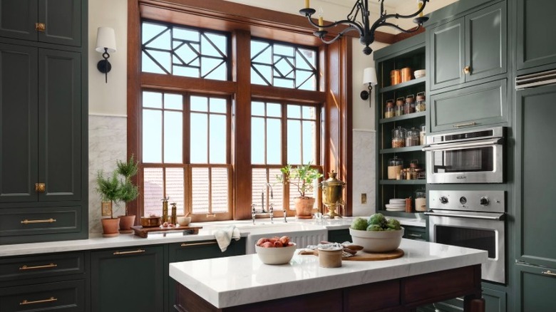 A kitchen with Cottage Grove green cabinets and wood window trim