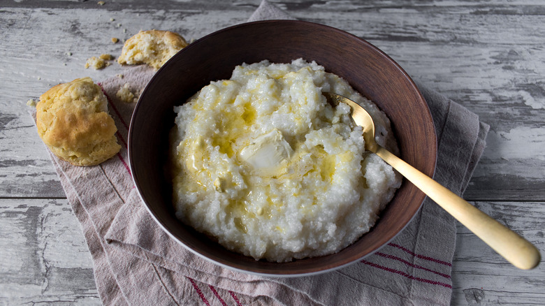 Bowl of grits served with butter and southern-style biscuits