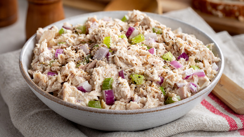 bowl of tuna salad with red onion with bread slices in background