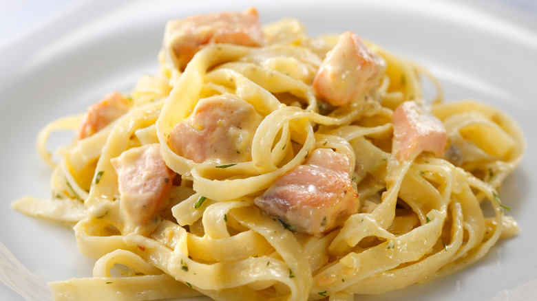 coins of salmon over alfredo pasta
