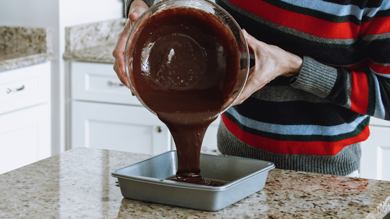 Person chocolate batter baking pan