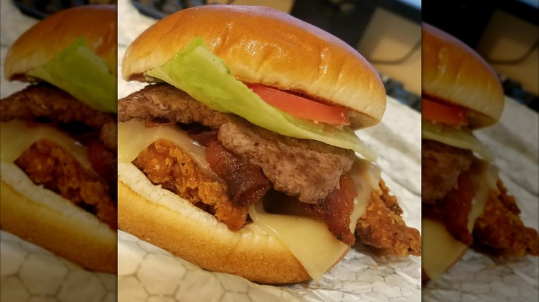 Barnyard burger with beef, chicken, bacon, lettuce, and tomato