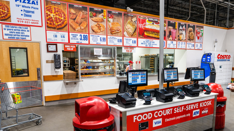 Costco's food court with self-serve kiosk in the front and menu pictures above the serving counter