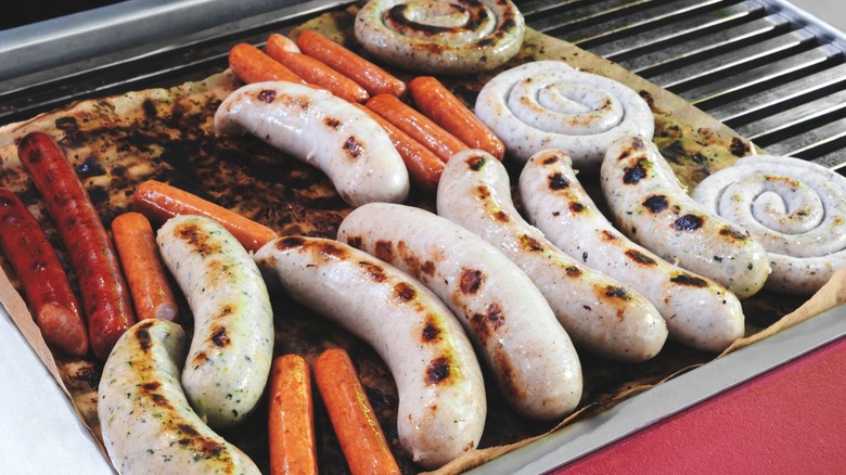 A grill with different types of sausage cooking on it