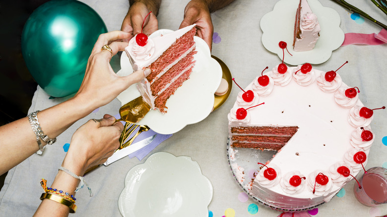 Top view of fodies slicing a round layer cake