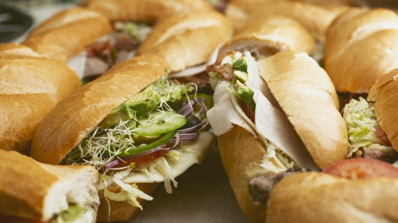 several grinder sandwiches stuffed with meat and veggies