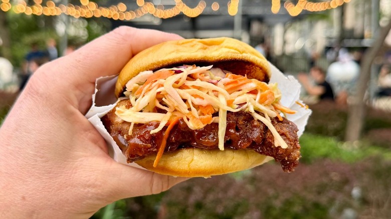 A closeup of a hand holding a BBQ Boneless Baby Back Rib Sandwich from Shake Shack