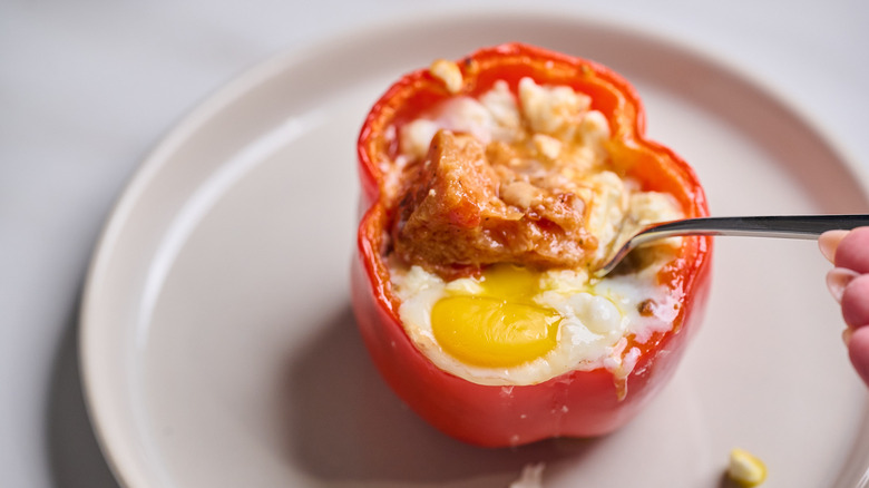 Spoon pulling shakshuka out of stuffed pepper