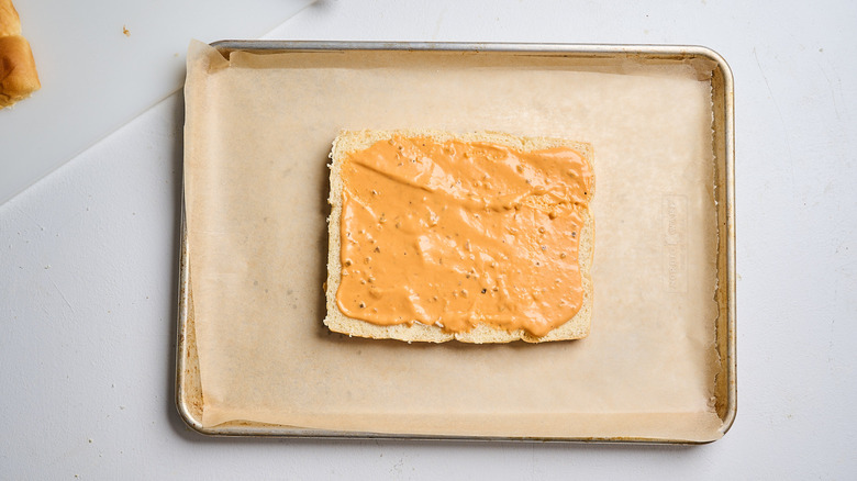 spreading dressing on bottom buns