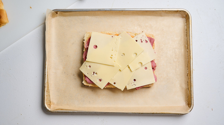 Bottom bun layered with corned beef and swiss