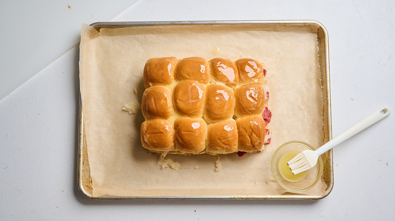 brushing top buns with butter