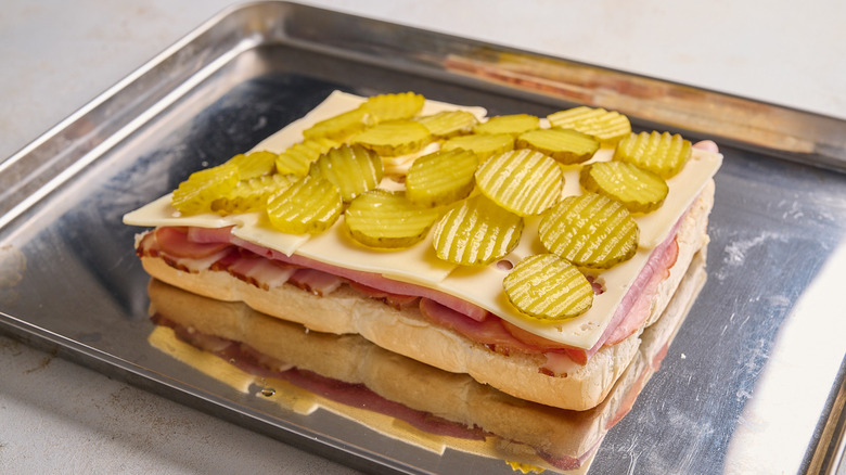 sliders layered with ham, cheese, and pickles