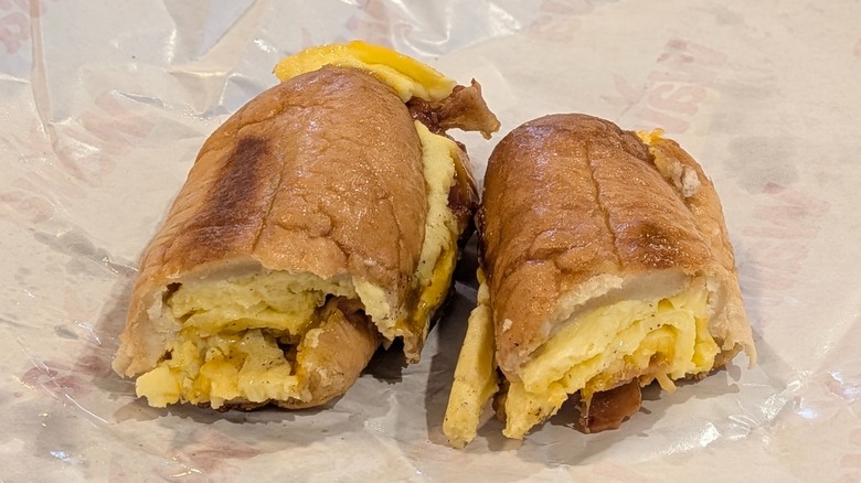 Wawa's breakfast hoagie with eggs, cheddar, and bacon cut in half on wax paper