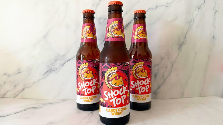 Three bottles of Shock Top Candy Corn Wheat Ale on marble surface