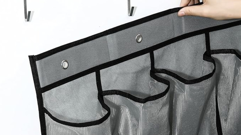 Person hanging over-the-door shoe organizer