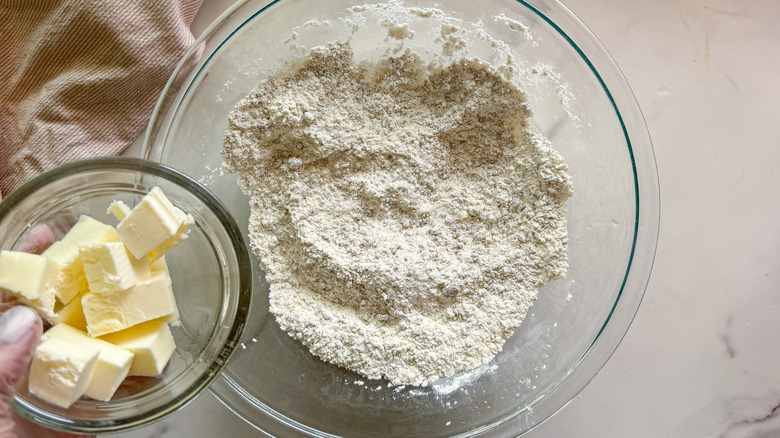 hand adding butter to bowl