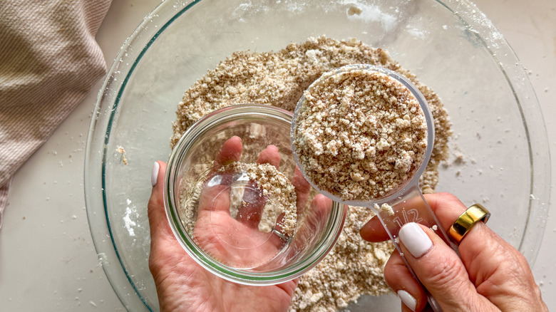 hand measuring out 1/2 cup
