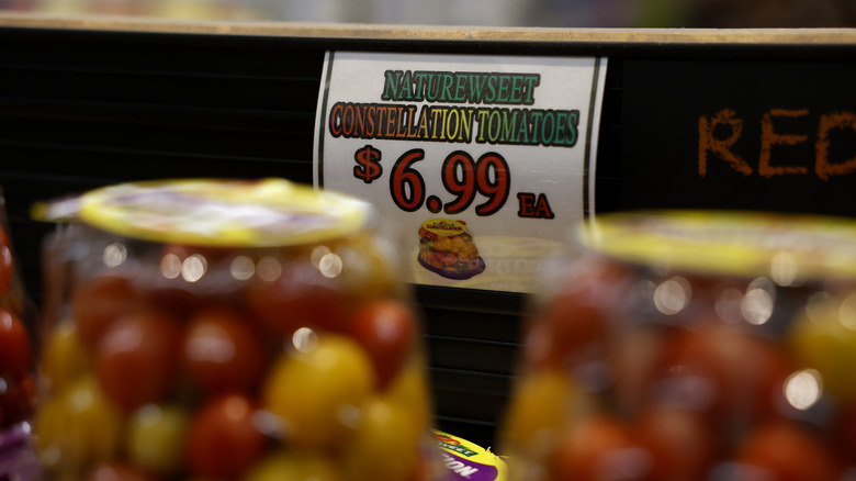 A display of tomatoes in a supermarket with a price tag that says $6.99 each