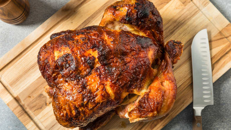 Rotisserie chicken on rectangular wooden board
