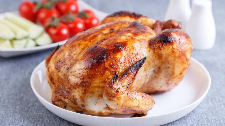 Cooked rotisserie chicken on white plate