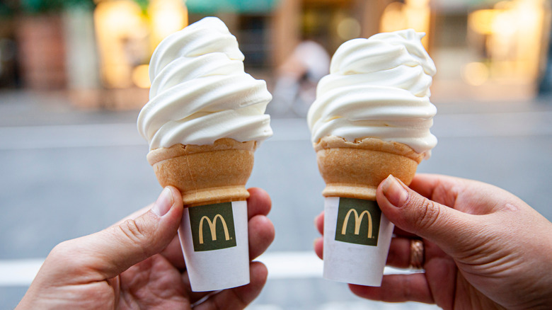 holding up two mcdonalds ice cream cones