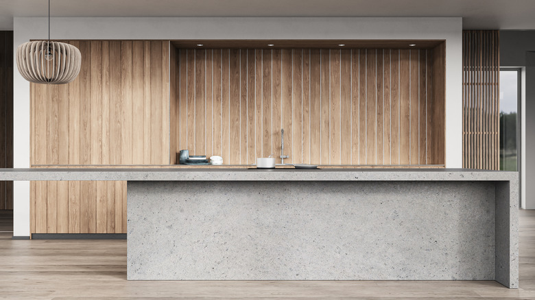 A kitchen with concrete countertops and wooden wall tiles